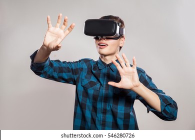 emotional funny man wearing virtual reality goggles. Studio portrait of video game designer wearing VR headset. studio shot isolated on gray background. - Powered by Shutterstock