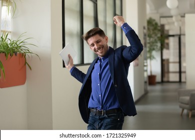 Emotional happy businessman celebrating successful project presentation in office. Male employee in suit raised hands feels happy by salary growth, got promoted concept. - Shutterstock ID 1721325949