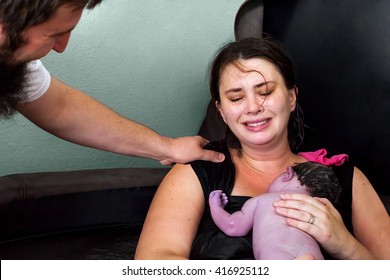 An Emotional Image Of A Father Congratulating His Wife For Giving Birth To Their New Son.  She And The Baby Are In The Birthing Tub After A Home Birth And She Is Crying Tears Of Joy.