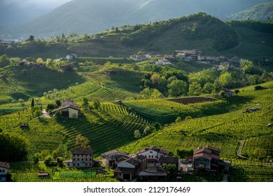 Emotional landscape with hills and vineyards in the Prosecco wine region in Italy, Unesco world heritage site, Valdobbiadene small town with European buildings and churchestowers, rural houses