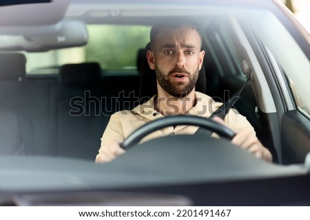 Emotional latin man driving a car, had an accident. Sad driver stuck in traffic. Transportation concept 	
