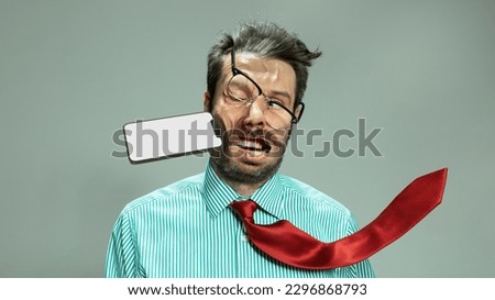 Emotional man, businessman in tie taking punch in face by flying smart phone. Concept of personal problems, financial loses, business fall, deadlines, economic crisis, bad investment. Ad, betting