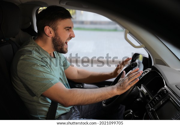 Emotional man in\
car. Aggressive driving\
behavior
