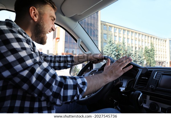 Emotional man in
car. Aggressive driving
behavior