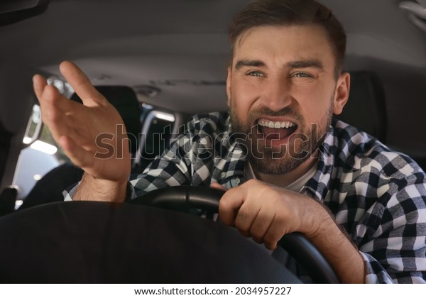Emotional man in\
car. Aggressive driving\
behavior
