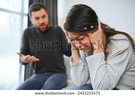 Emotional man gesturing and shouting at his wife, young couple having quarrel at home. Domestic abuse concept.