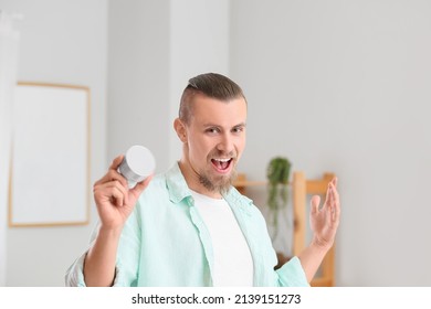 Emotional Man Holding Wireless Portable Speaker In Room