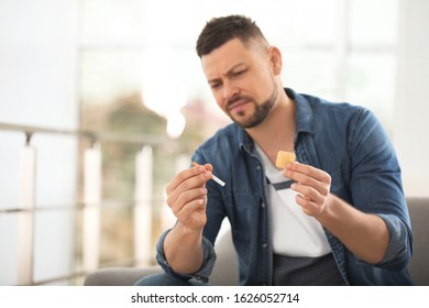 Emotional Man With Nicotine Patch And Cigarette At Home