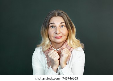 Emotional Mature Woman Raising Eyebrows, Having Fascinated Look, Staring At Camera In Anticipation With Fists Clenched, Expecting To Hear Positive News. Human Emotions, Feelings And Reaction