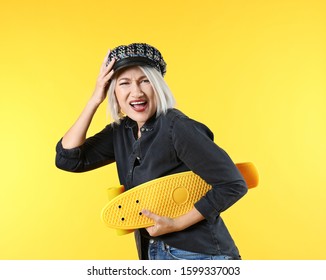 Emotional Mature Woman With Skateboard On Color Background