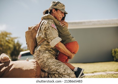 Emotional Military Mom Embracing Her Son After Returning Home From The Army. Courageous Female Soldier Reuniting With Her Young Child After Military Deployment.