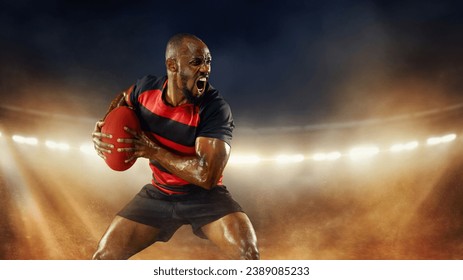 Emotional and motivated African-American young man, rugby player in motions over dark stadium with flashlight and smoke. Concept of professional sport, competition, motivation, game, championship - Powered by Shutterstock