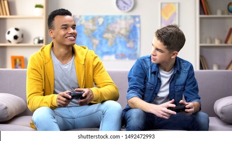 Emotional Multiracial Male Teen Friends Playing Video Game, Hobby And Rivalry