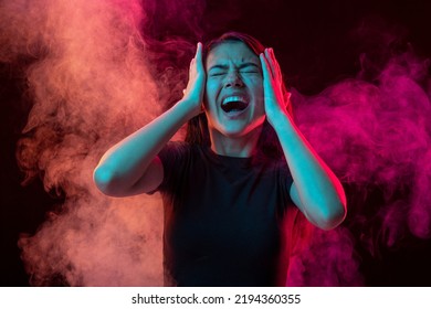 Emotional pain. Young dark hair woman shouting isolated over pink background with clouds of smoke. Concept of mental health, art, human emotions, challenges, ad - Shutterstock ID 2194360355