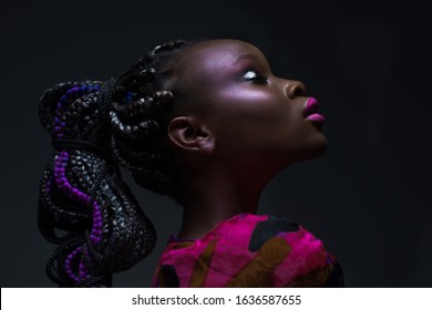 Emotional Portrait African Woman With Closed Eyes Fashionable Makeup And Hairstyle In Studio.Dark Skinned Model With Bright Make Up Raised Head And Closed Eyes In Bright Dress On Black Background