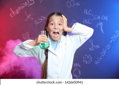 Emotional pupil holding Florence flask in smoke against blackboard with chemistry formulas