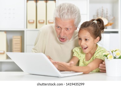 Emotional senior man with granddaughter using laptop - Powered by Shutterstock