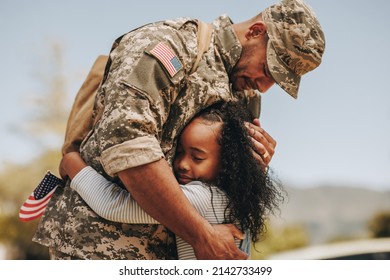 Emotional soldier saying his goodbye to his daughter before going to war. Patriotic serviceman embracing his child before leaving to go serve his country in the military.