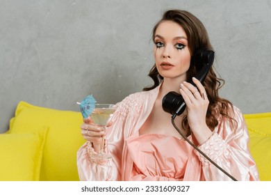 emotional stress, sad woman with smudged mascara sitting on yellow couch, housewife with crying eyes talking on retro phone, holding cocktail, feeling lonely and depressed, heartbroken wife at home - Shutterstock ID 2331609327