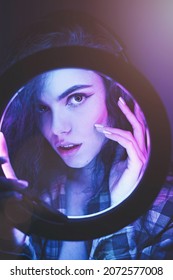 Emotional Studio Portrait Young Woman In A Wireless Headphones With Ring Flash Effect. Round LED Circle Lamp.