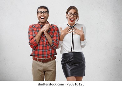 Emotional surprised happy woman and man wear glasses, have unbelivable expression, as see present surprise prepared by friends, don`t expect to recieve so many compliments. Astonishment concept