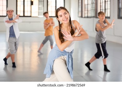 Emotional teenage girl having group dance training in studio, performing dynamic elements - Powered by Shutterstock