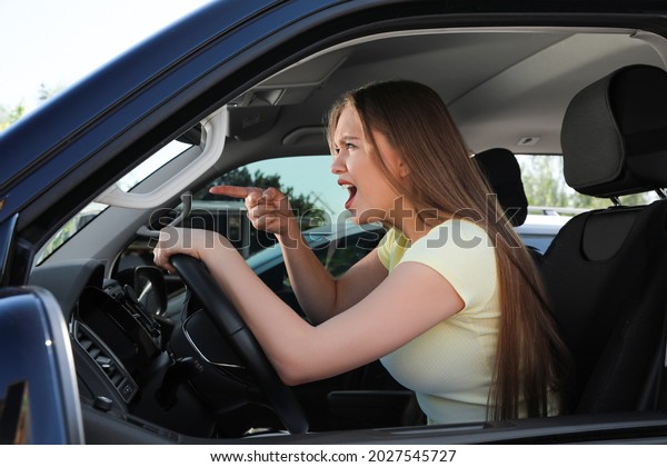 Emotional woman\
in car. Aggressive driving\
behavior