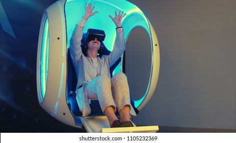 Emotional woman experiencing virtual reality in a moving interactive chair - Powered by Shutterstock