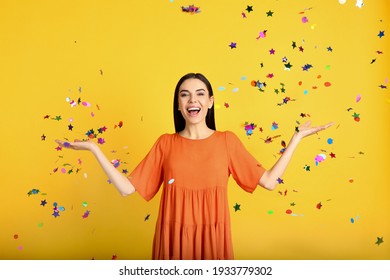 Emotional Woman And Falling Confetti On Yellow Background