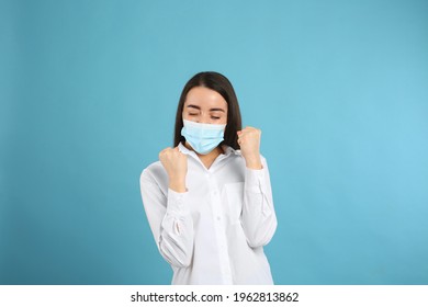 Emotional Woman With Protective Mask On Light Blue Background. Strong Immunity Concept