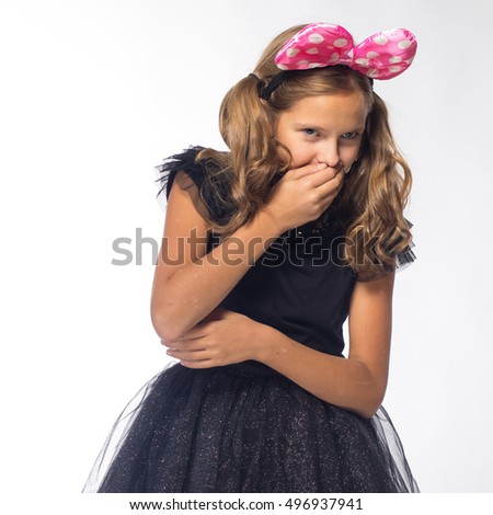 Emotional young blond woman in a black dress with a pink bow on a white background