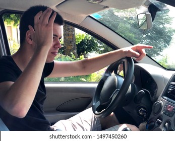 Emotional Young Driver Showing His Anger With Gestures. Bad Driving Concept 