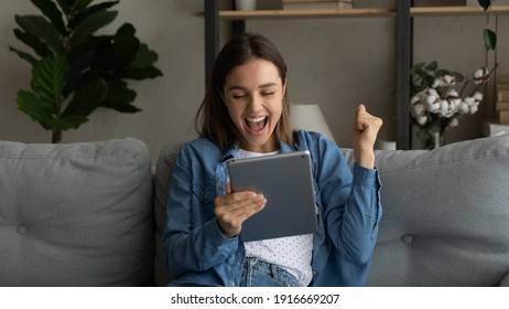 Emotional young female sport fan scream yes watch winning victory of favorite team on pad pc online. Excited woman student read email from college about getting scholarship for personal achievement - Shutterstock ID 1916669207