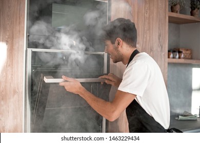 Emotional Young Man Standing Near Broken Oven