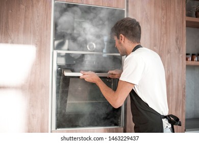 Emotional Young Man Standing Near Broken Oven