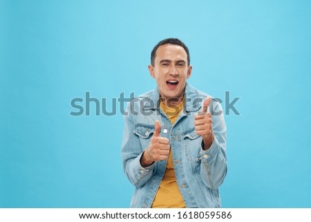emotional young man in yellow t-shirt and denim jacket positive gesture