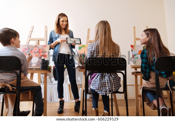 Emotional young teacher explaining new topic in\
the art school