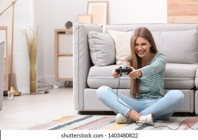 Emotional young woman playing video games at home - Shutterstock ID 1403480822