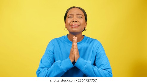 Emotional young woman prays and pleads, begging and upset, yellow studio - Shutterstock ID 2364727757