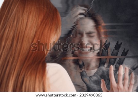 Emotional young woman suffering from hallucinations. Hand touching broken mirror on backside, glitch effect