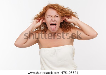 Emotions concept. Picture of mature or middle aged woman fooling isolated on white background in studio. Beautiful lady playing tricks.