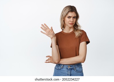 Emotions And Gestures. Picky And Skeptical Blond Woman Say No, Wave Hand In Refusal Gest, Rejecting Something With Reluctance, Standing Over White Background