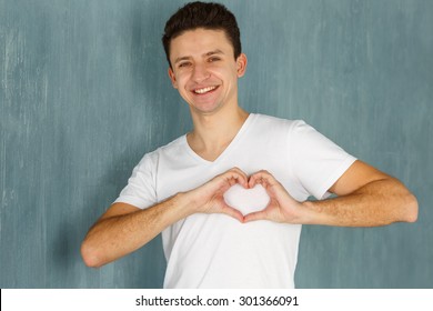 Emotions Man. Man Showing Hand Sign Heart On His Chest. Joy, Happiness, Love - Sincere Emotions Young Man. Concept - For The Charity, Fund Support World. Man Making A Heart Shape With His Hands.