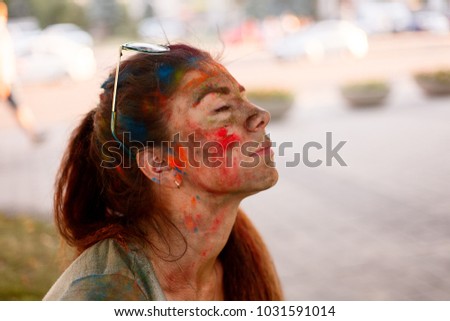 emotions, people, beauty, fashion and lifestyle concept - Portrait of a beautiful girl full of colored powder all over the body