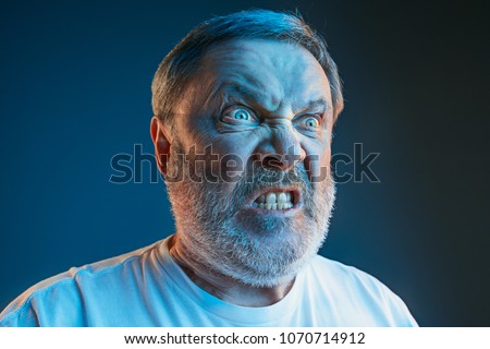Emotions of a television fan. Screaming, hate, rage. Crying emotional angry man screaming in colorful bright lights at studio. Emotional, mature face. Human, facial expression concept.
