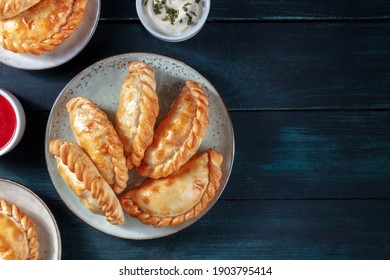 Empanadas dinner, shot from the top on a dark blue rustic wooden background with copy space