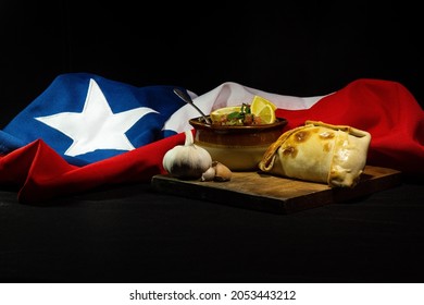 empanadas and pebre, traditional food of national holidays in Chile, background the Chilean flag