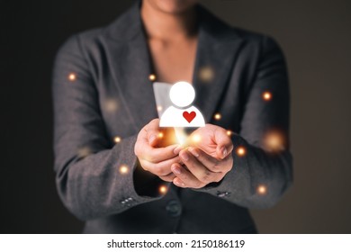 Empathy female manager holding human icon with heart shape over palm hands. Power of emotional intelligent, soft skill development concept. - Shutterstock ID 2150186119