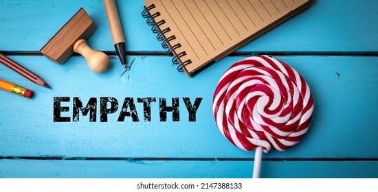 Empathy. Office Supplies And Candy On A Blue Wooden Table.