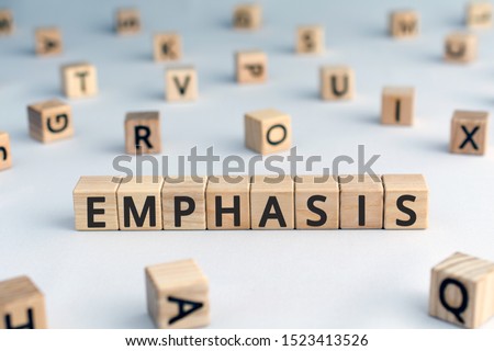emphasis - word from wooden blocks with letters, special attention given to something emphasis concept, random letters around, white  background